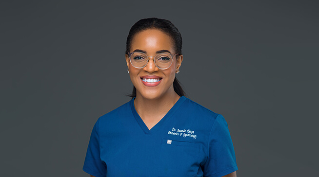 woman wearing blue scrubs and glasses