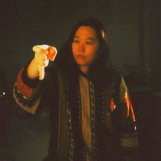 Person mit langen Haaren, die im Dunkeln eine Daumen-down-Geste macht.