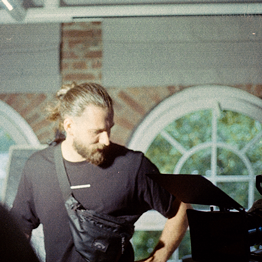 Junge Frau lächelt und zeigt mit beiden Händen das Friedenszeichen.