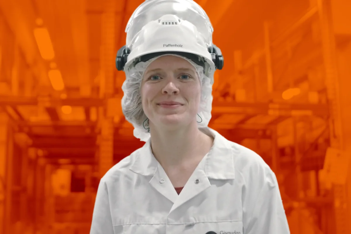 Mitarbeiterin mit Schutzhelm und Haarnetz in der Produktion von Givaudan