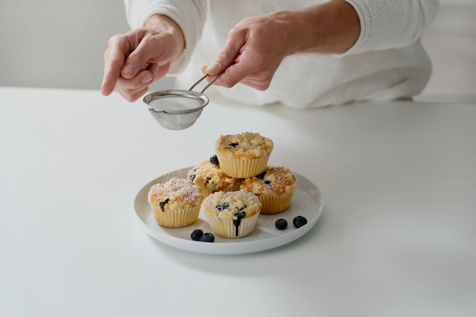 Puderzucker wird über Blaubeermuffins gestäubt, Food-Styling für SEVERIN