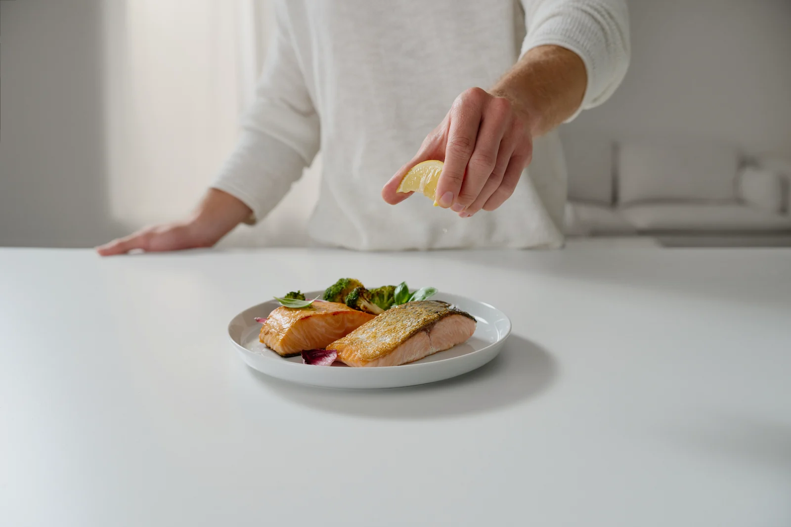 Food-Styling am Set: Zitrone wird über Lachs aus dem SEVERIN AI-Fryer geträufelt