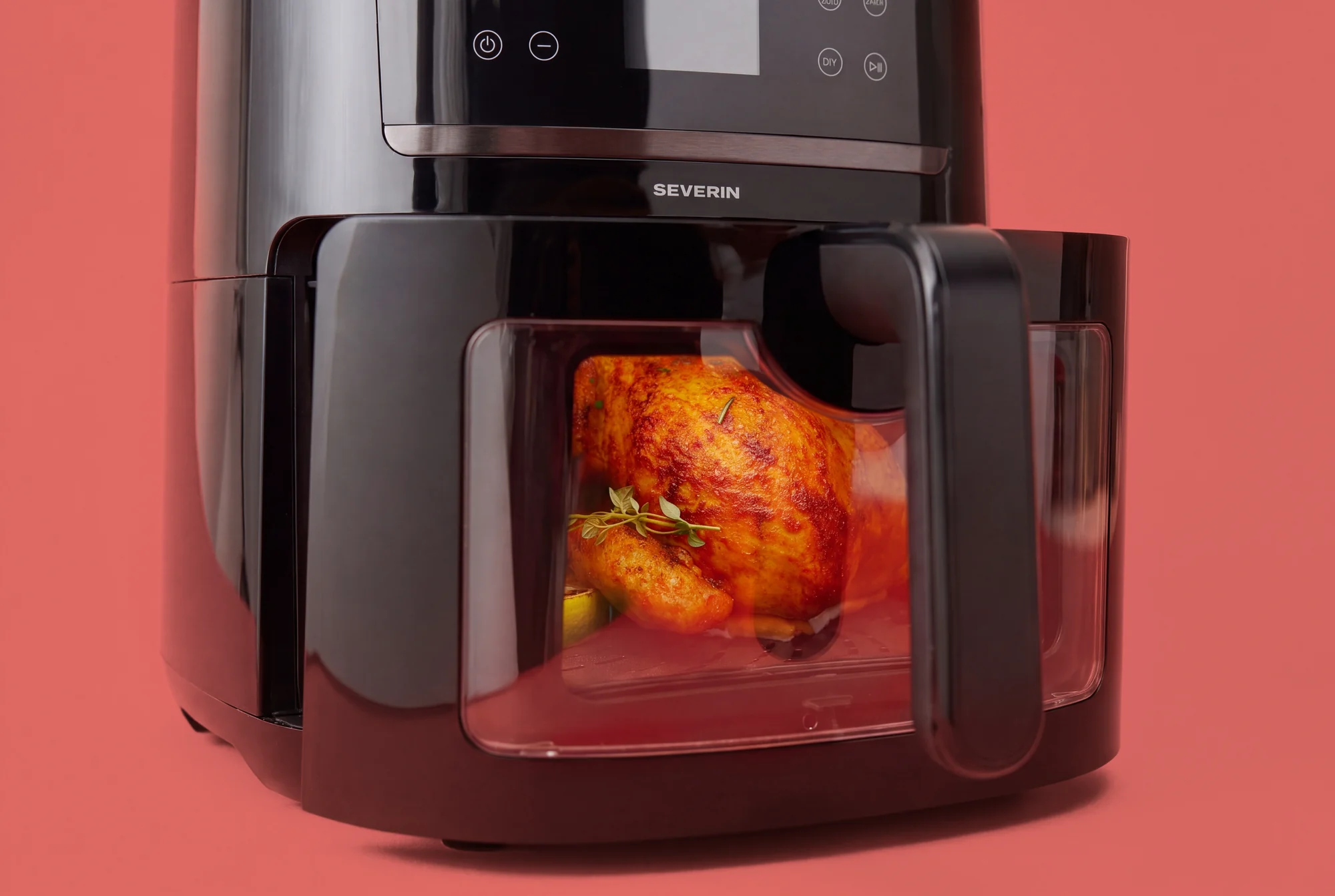 SEVERIN AI-Fryer mit Hähnchen im Sichtfenster vor rotem Hintergrund