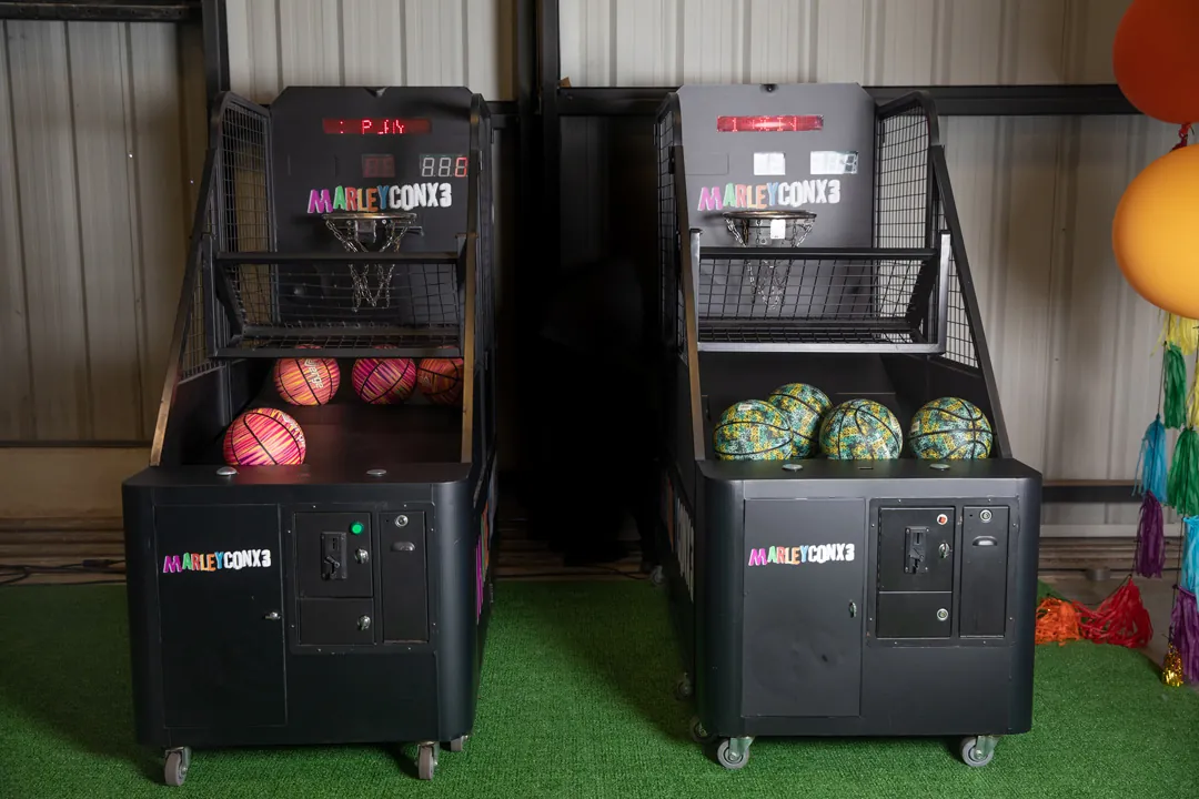 Two MarleyCon x 3 branded basketball arcade games on turf inside The Executive Hangar