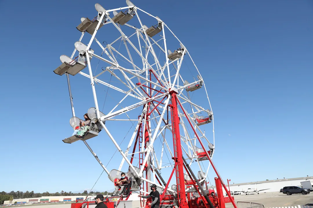 Ferris wheel carrying party guests against a blue sky on the tarmac at The Executive Hangar