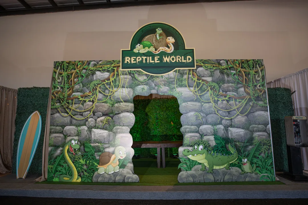 Reptile World themed stone archway with cartoon snake, turtle and crocodile inside The Executive Hangar