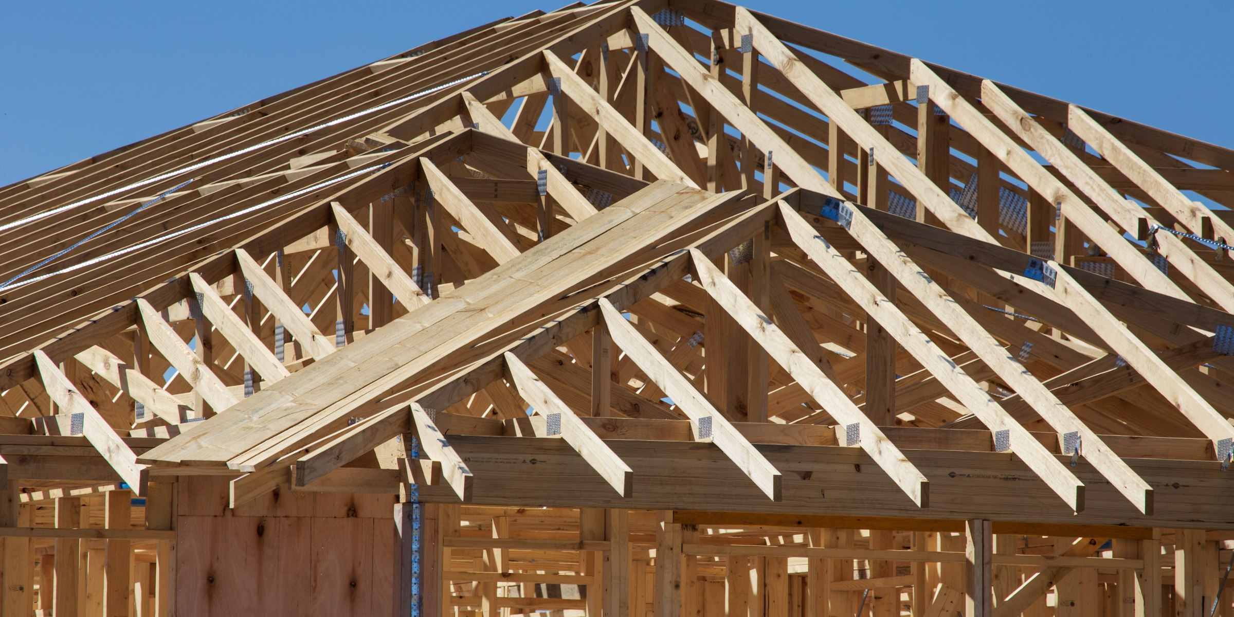 Wood-framed new home under construction with roof trusses
