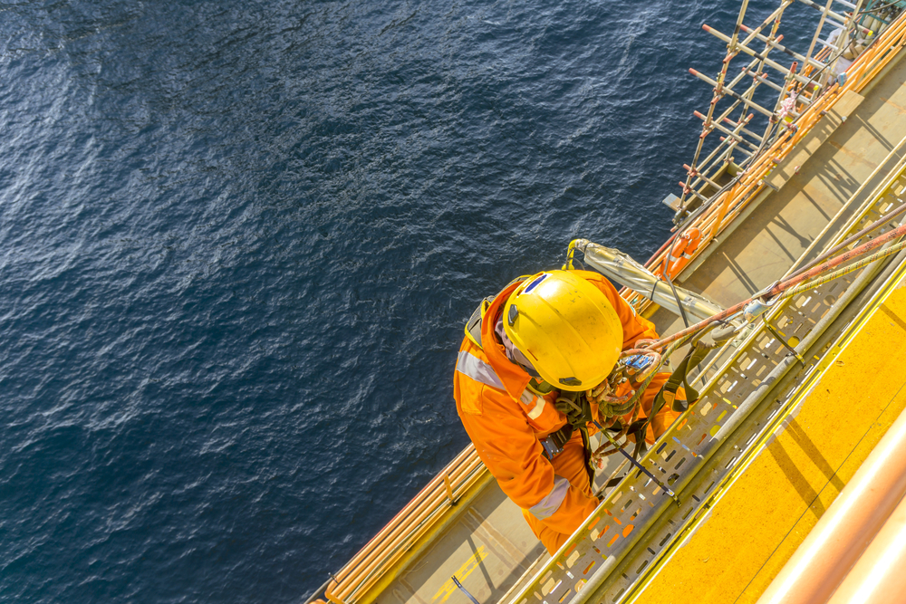 Abseiler climbing an offshore oil and gas rig