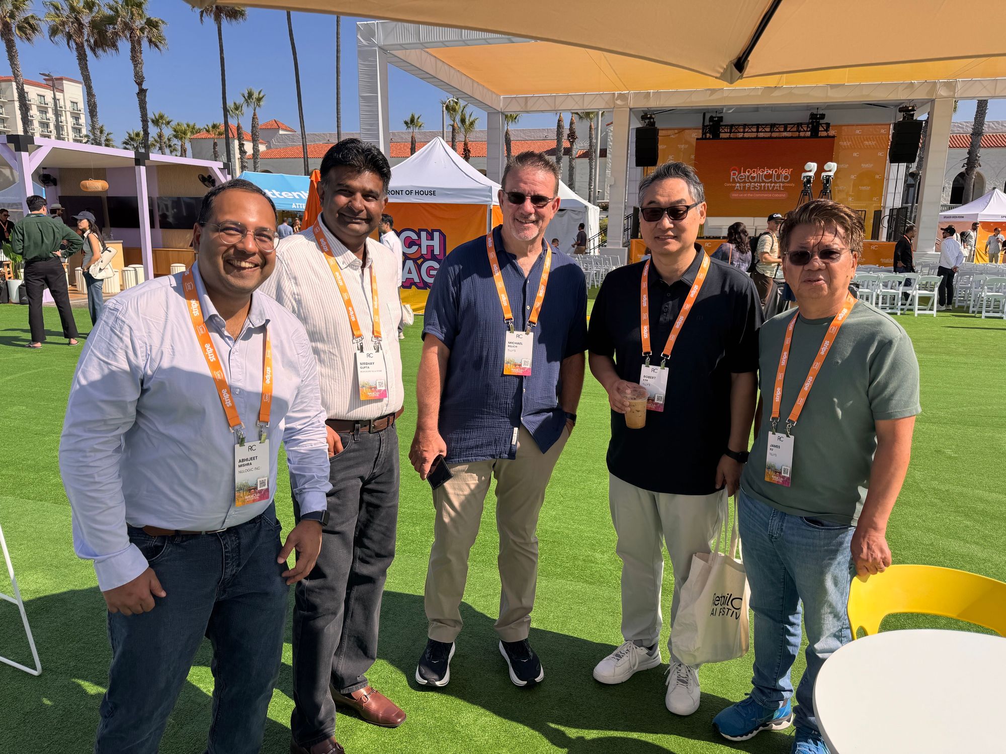 Abhijeet Mishra y Michael Relich con tres asistentes en el césped del festival, con el escenario principal detrás