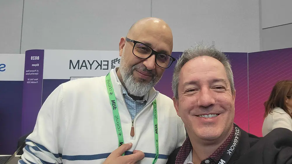 Two people smiling in front of the Ekyam booth number 8028
