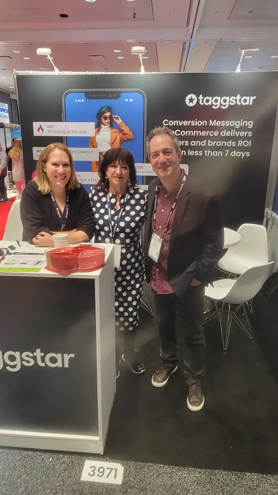 Three people standing at the Taggstar booth