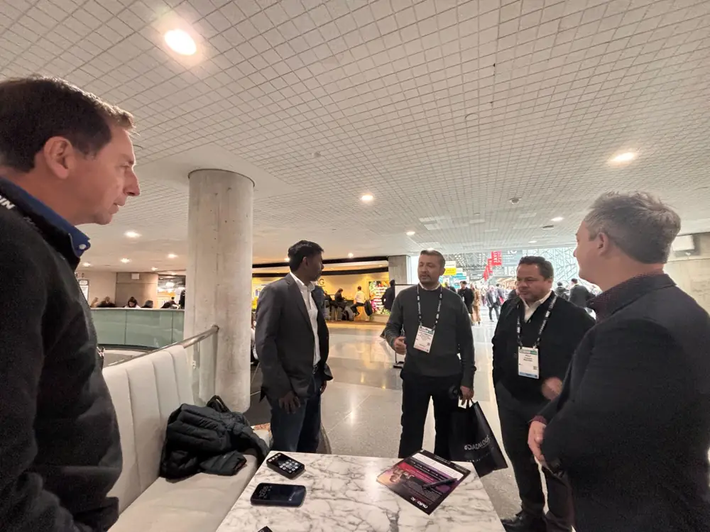 A group standing around a marble table with phones and printed collateral