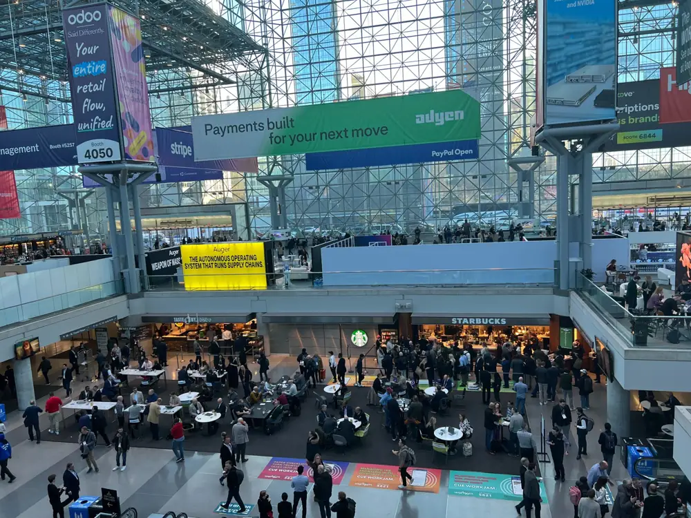 View from above of the Javits atrium with Adyen, Stripe and Odoo banners and the main concourse below