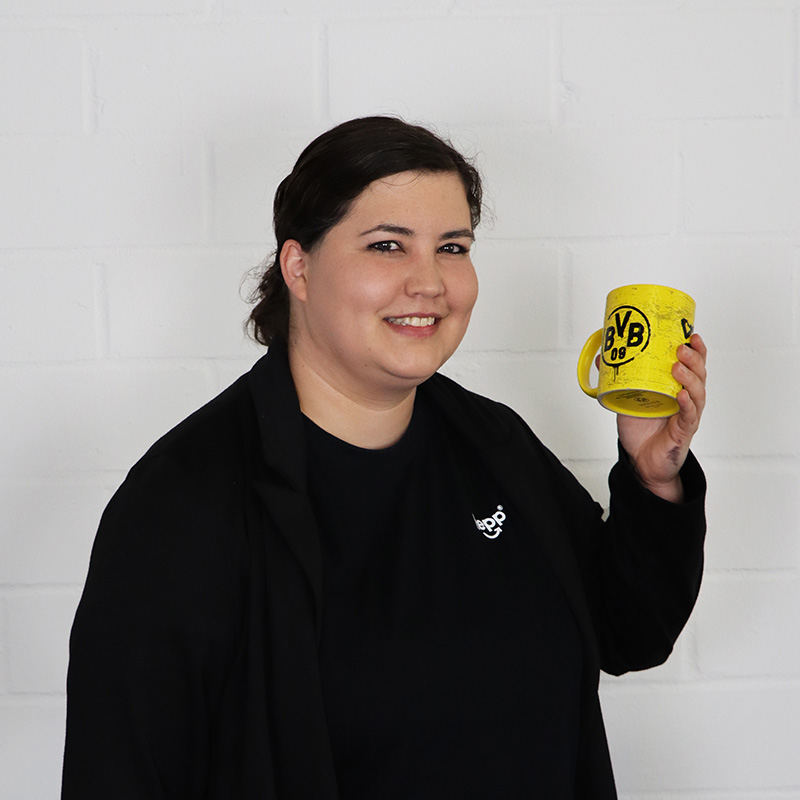 Porträt von Lisa Sommer mit einer BVB-Kaffeetasse in der Hand