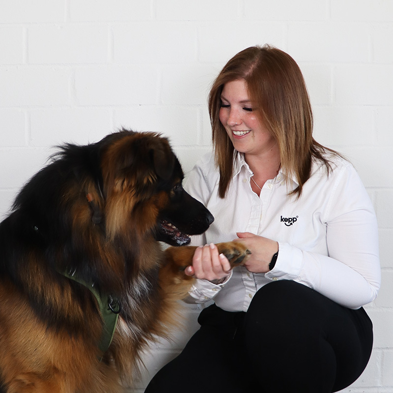 Porträt von Julia Wolframm mit einem großen Hund, der ihr Pfötchen gibt