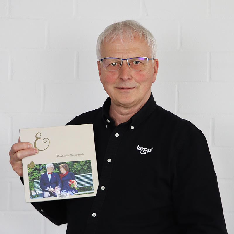 Porträt von Burkhard Marten, der ein Fotobuch in der Hand hält