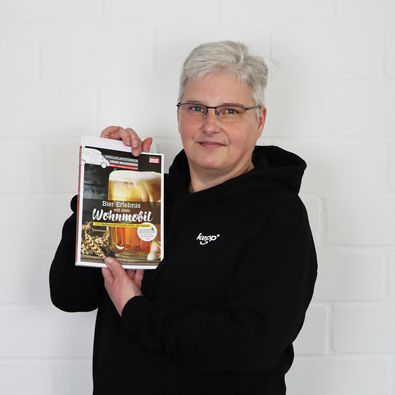 Porträt von Monika König mit einem Buch in der Hand