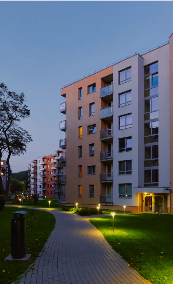 A walkway in front of a building at night.