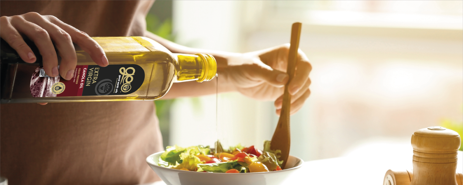woman pouring geo earth oils in salad