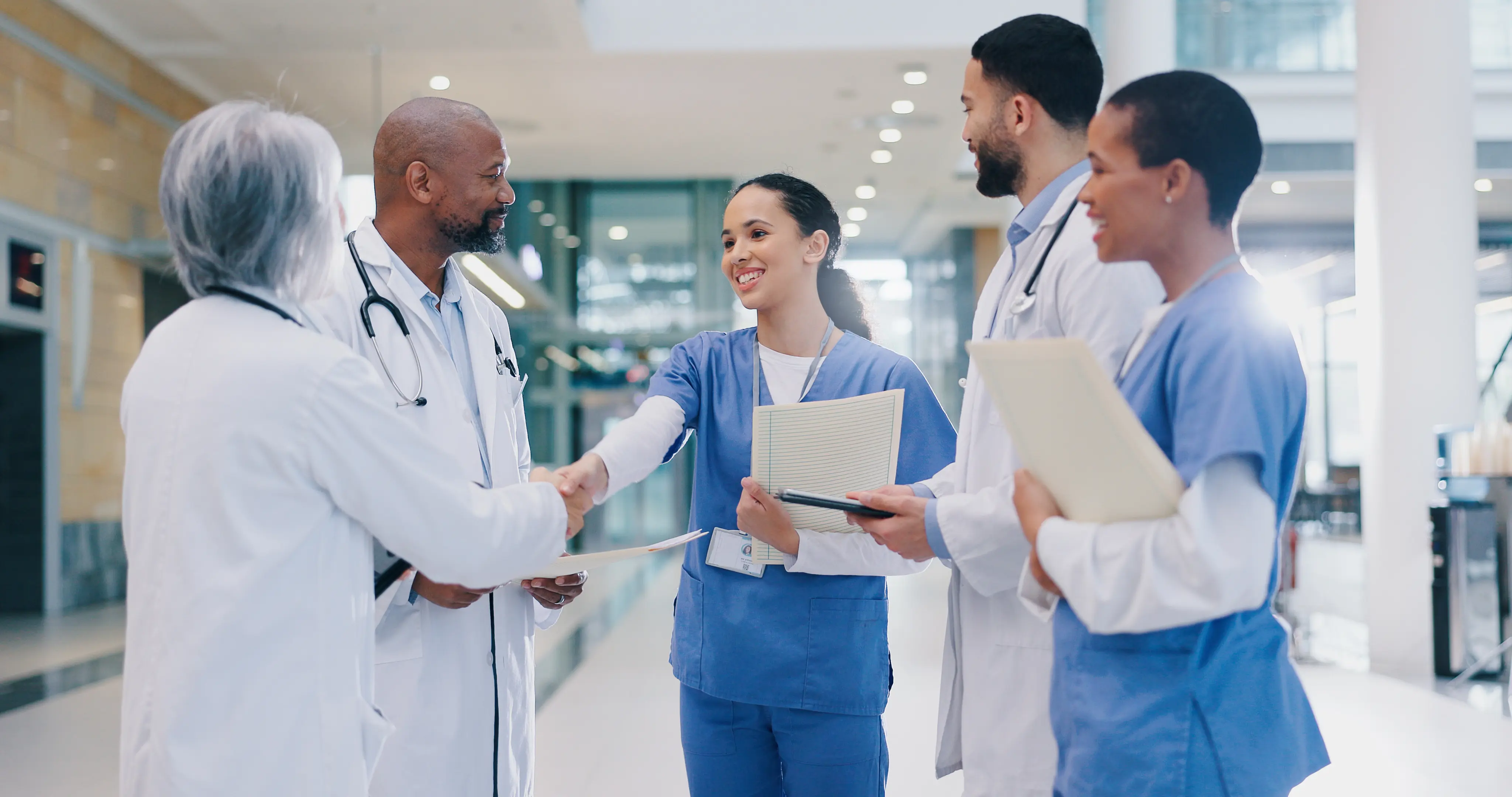 Doctors and nurses standing and talking in hospital setting about Joint Commission on site survey for hip and knee certification 