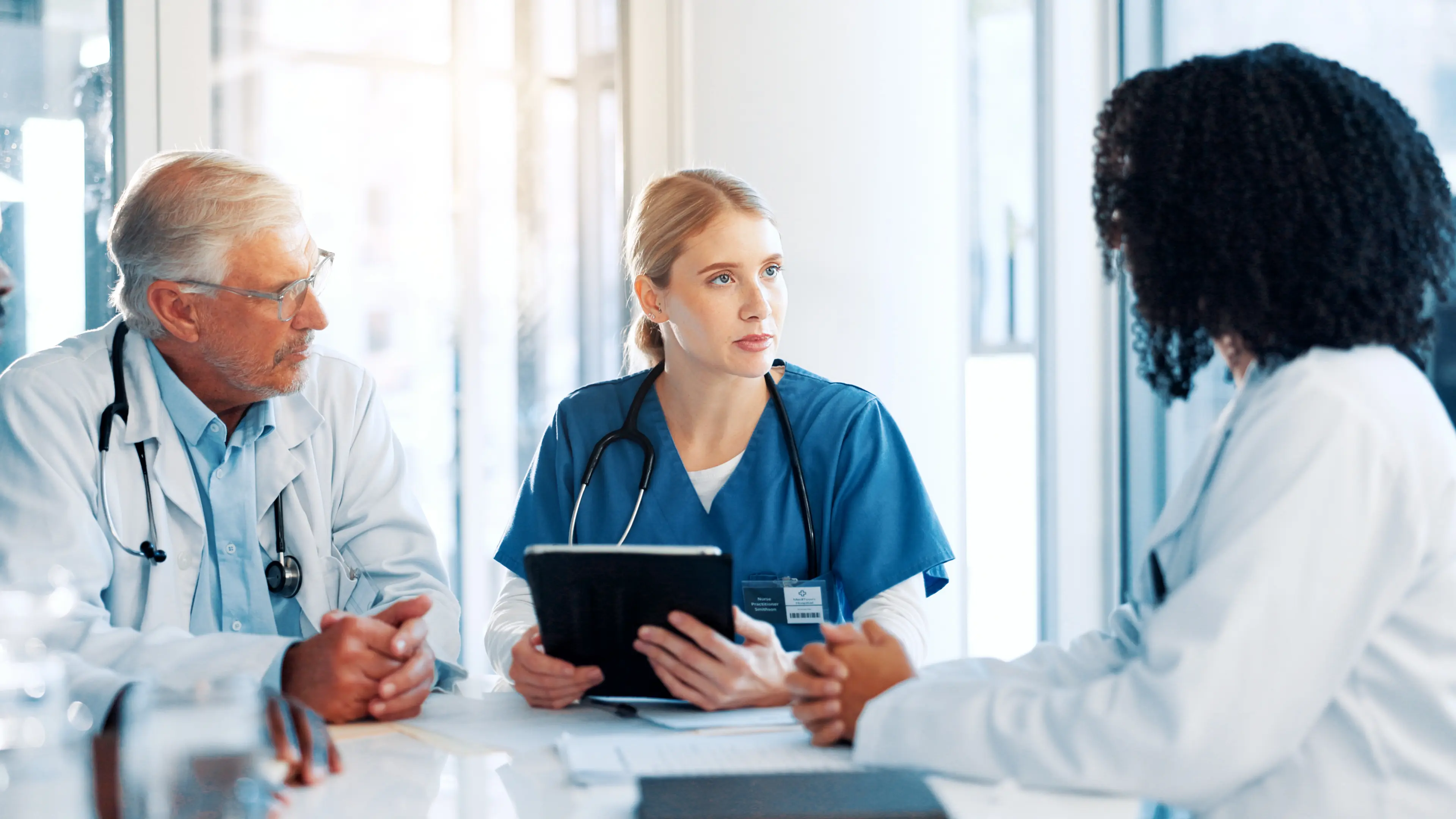 Physicians discussing revenue improvement due to use of digital patient management.