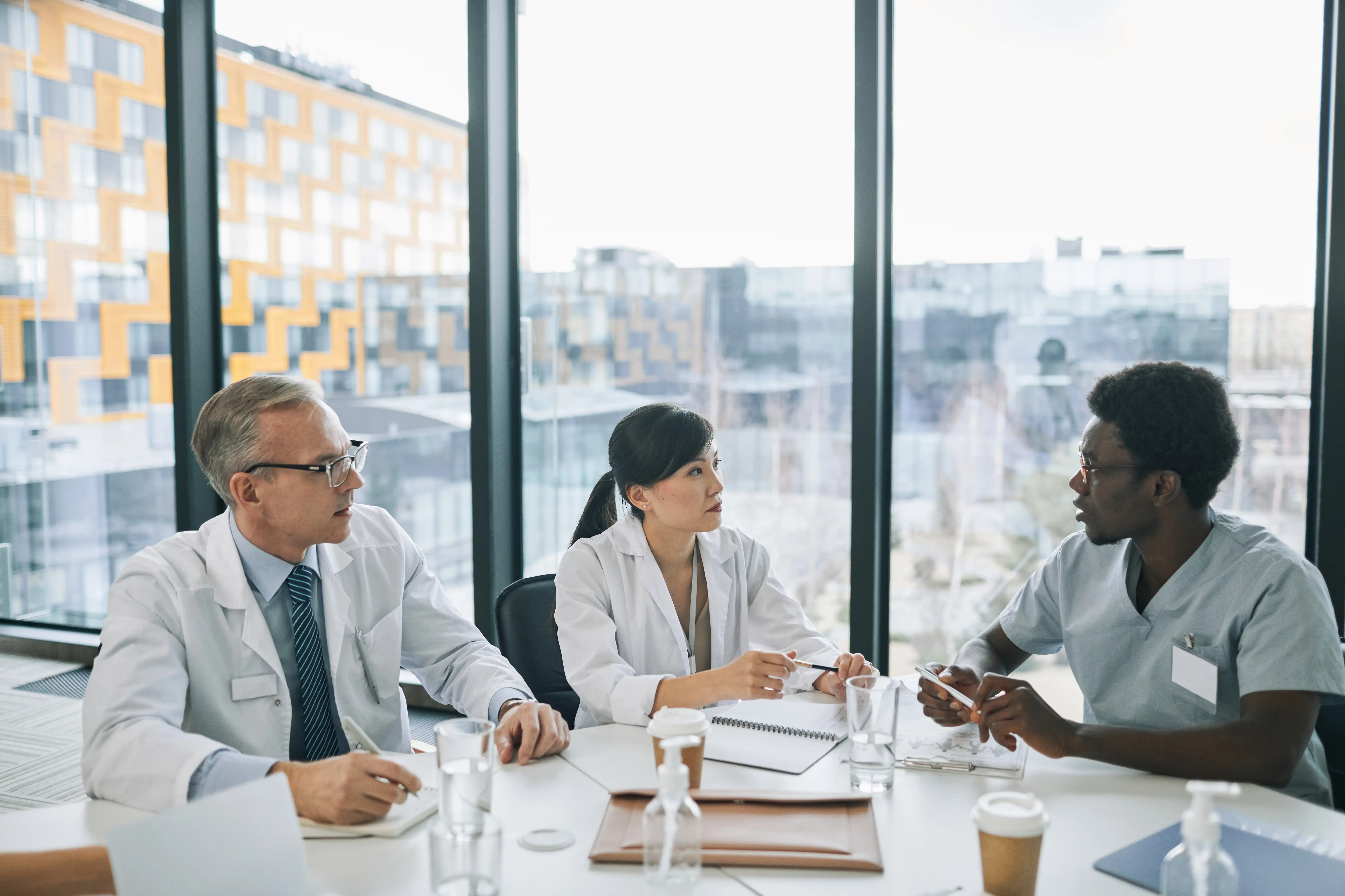 Two doctors and a nurse discussing the Transforming Episode Accountability Model (TEAM) requirements.