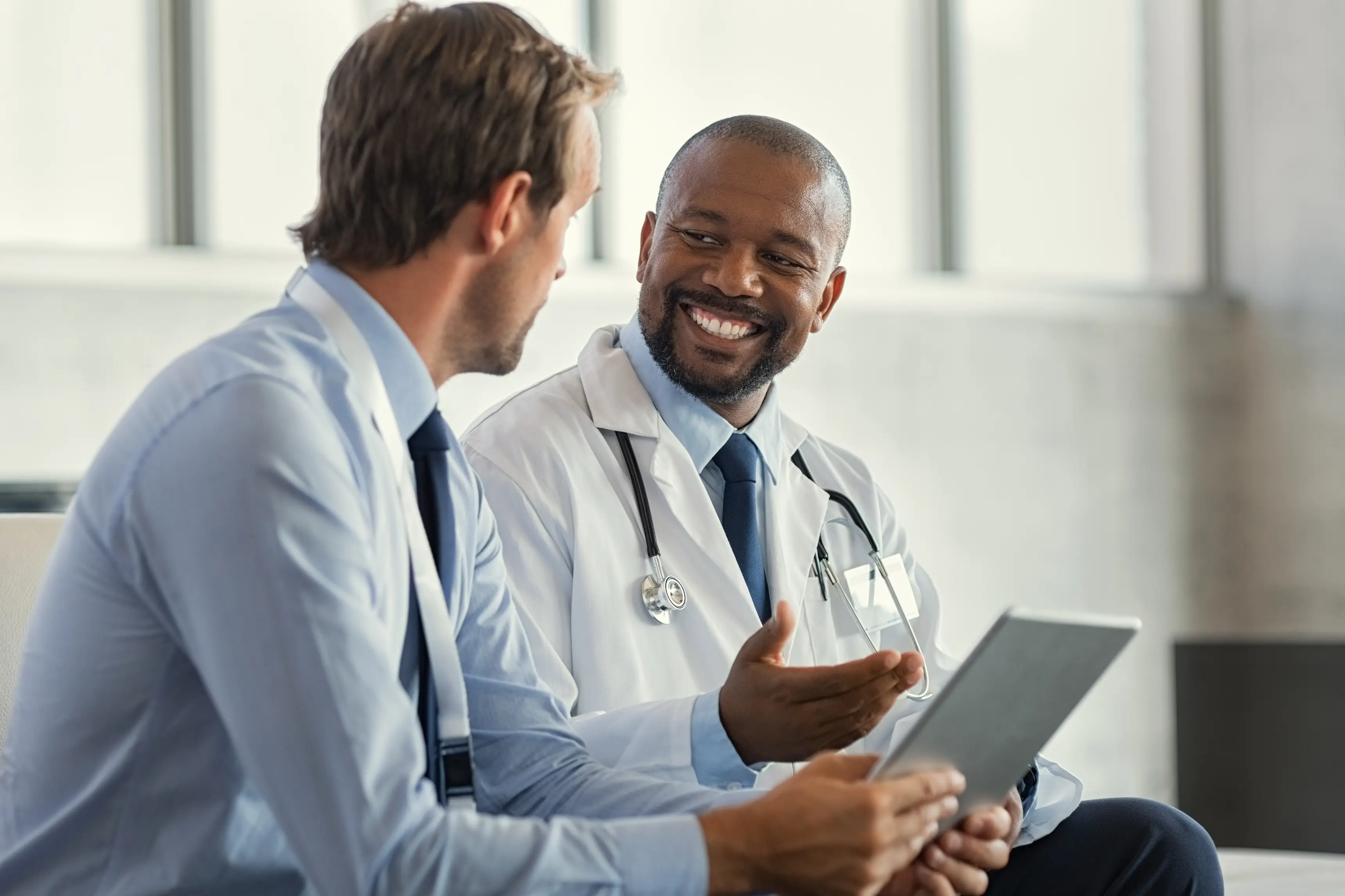 Two clinicians having a discussion while viewing Force Therapeutics compliance data on a tablet.