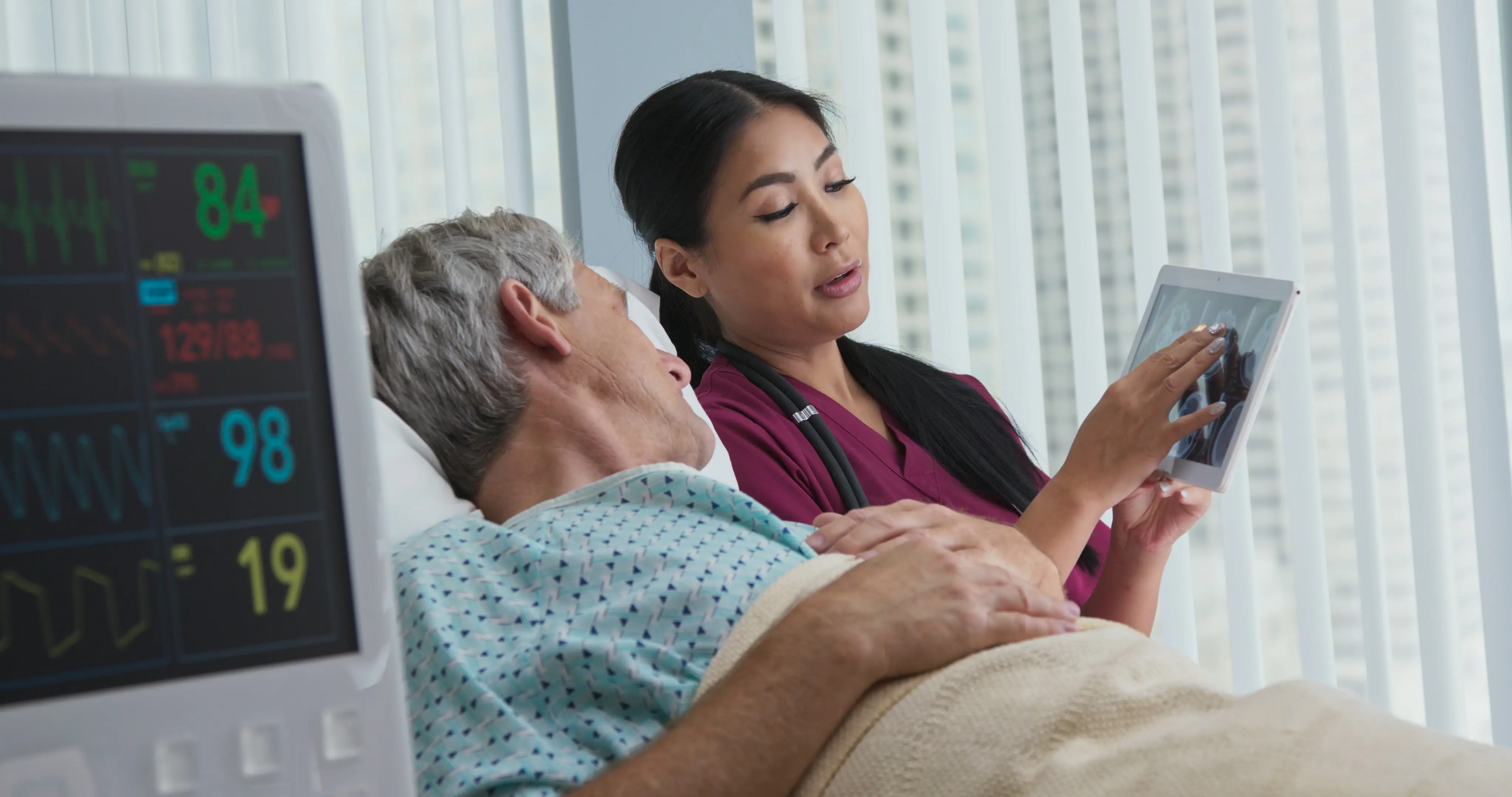 Nurse showing patient educational resources in Force Therapeutics app on tablet.