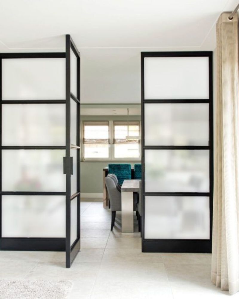 Schwarze Lofttüren mit Milchglas als elegante Raumtrennung zum Schlafzimmer