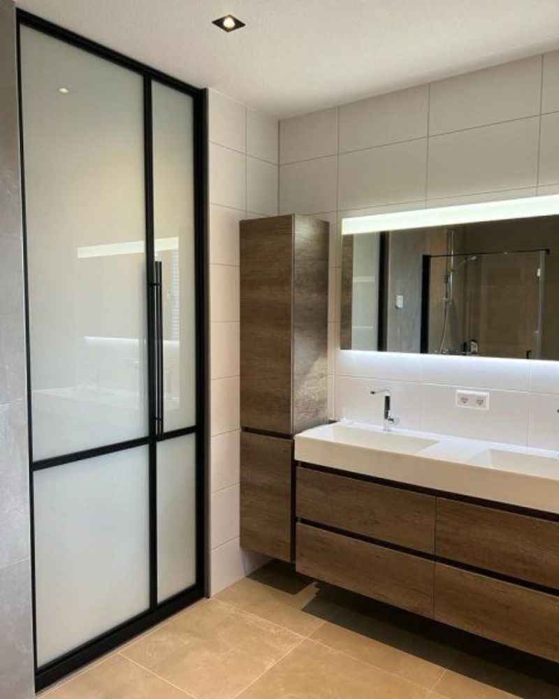Loft-Schiebetür mit schwarzem Rahmen und Milchglas als elegante Lösung im modernen Badezimmer.