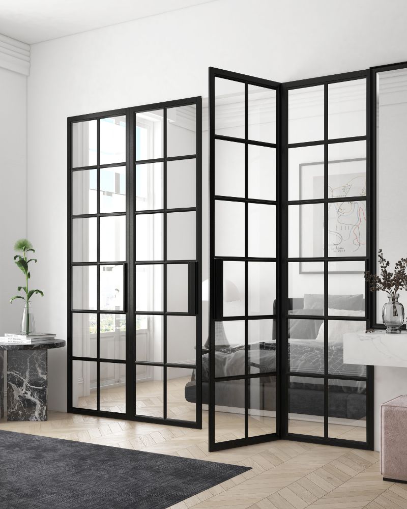 Elegante Lofttüren mit schwarzem Stahlrahmen und Glas als Raumtrenner zwischen Wohnzimmer und Schlafzimmer