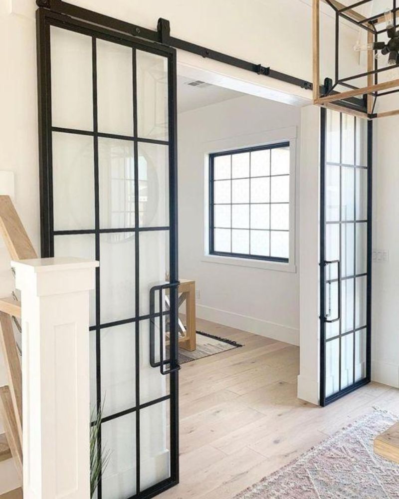 Zweiflügelige Loft-Schiebetüren mit schwarzen Stahlrahmen und Sprossen