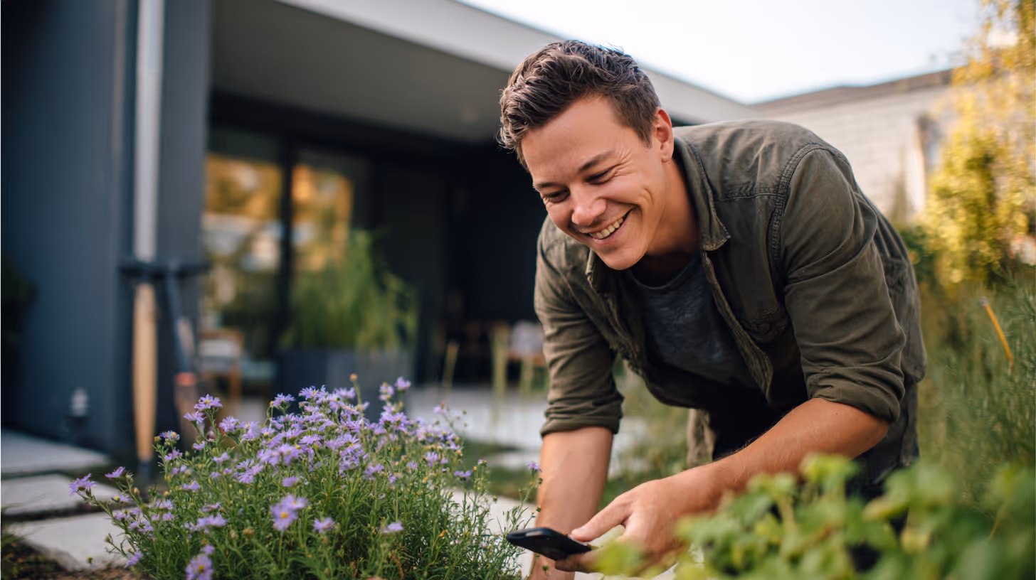 A happy house guardian briefly glances at his phone while working.