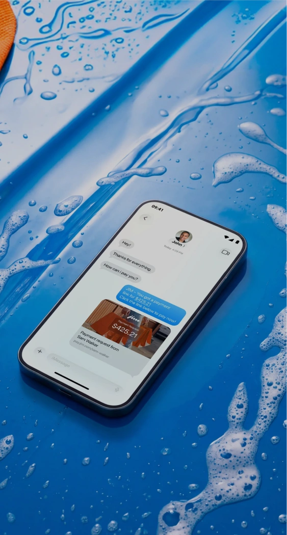 Smartphone on blue surface showing payment link message for $425.21 from Sam Walker.