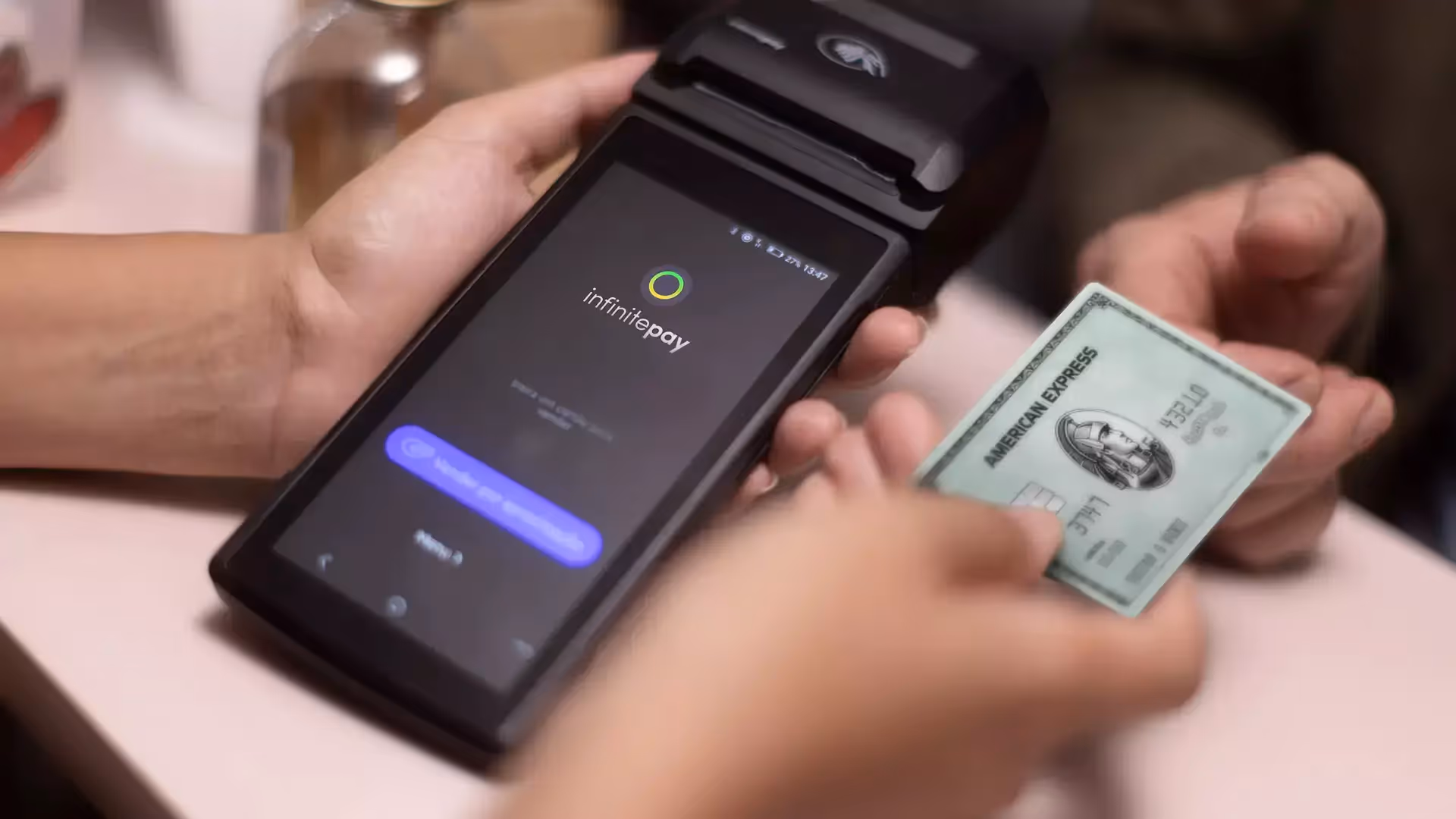what is nfc? Person making a contactless payment with an American Express card on an InfinitePay card reader.