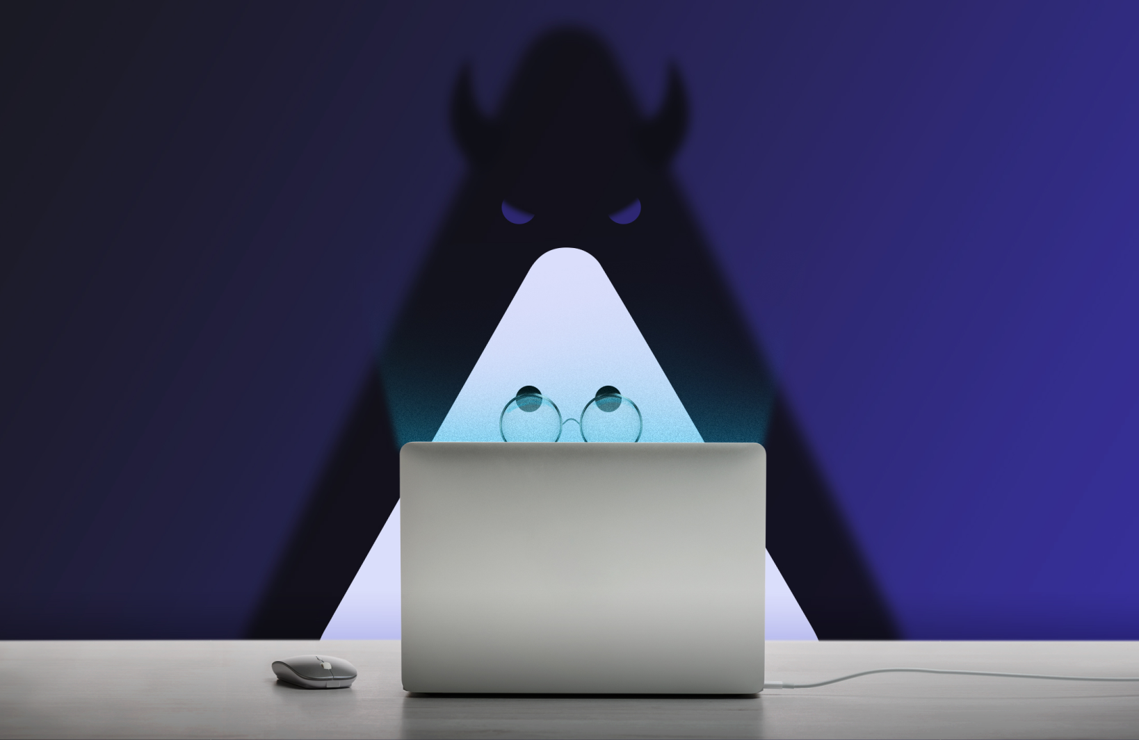 Un nacho face à son ordinateur portable est menacé par une ombre cornue qui le surveille sans qu'il ne s'en aperçoive