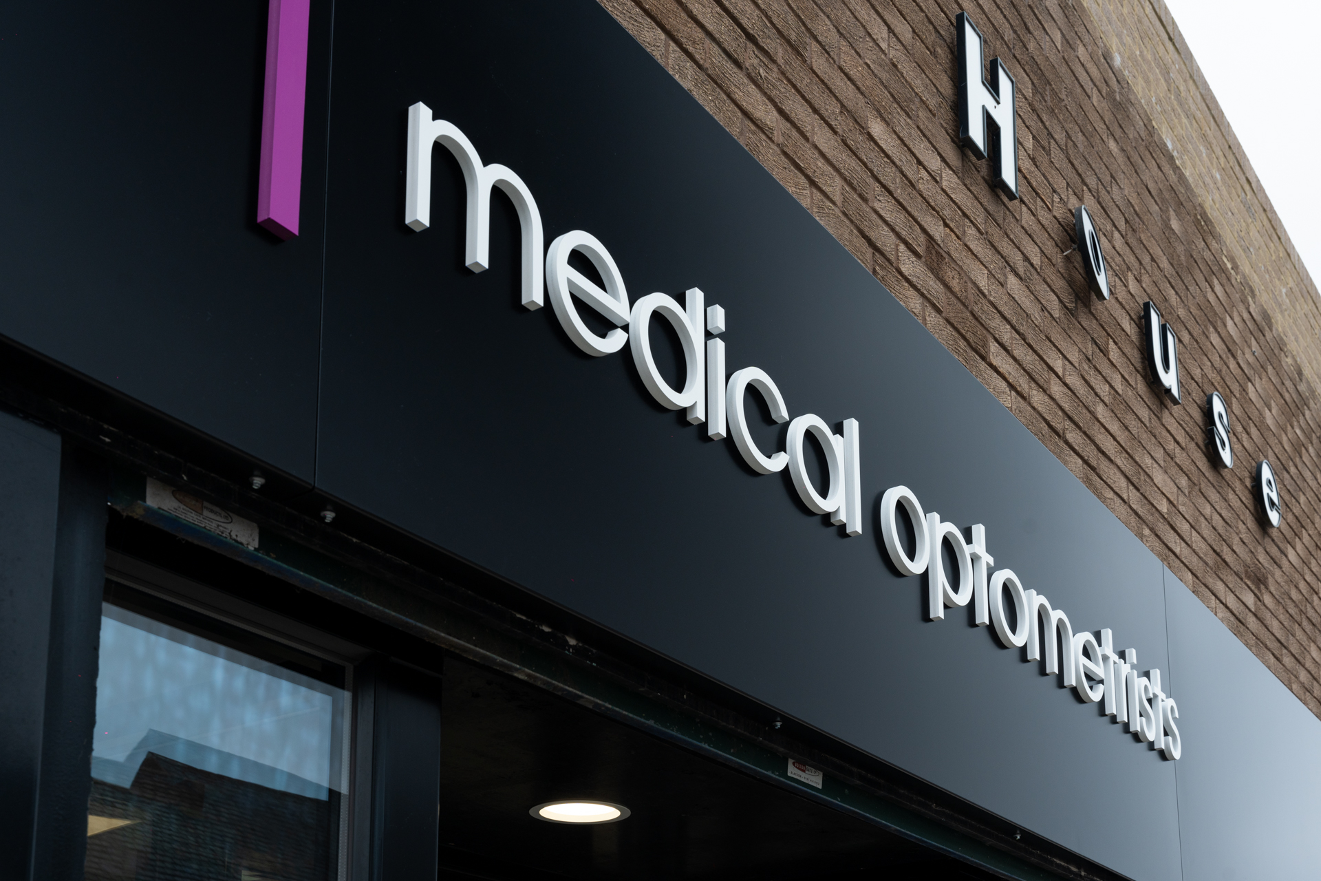 Medical optometrists storefront with white letters on dark background