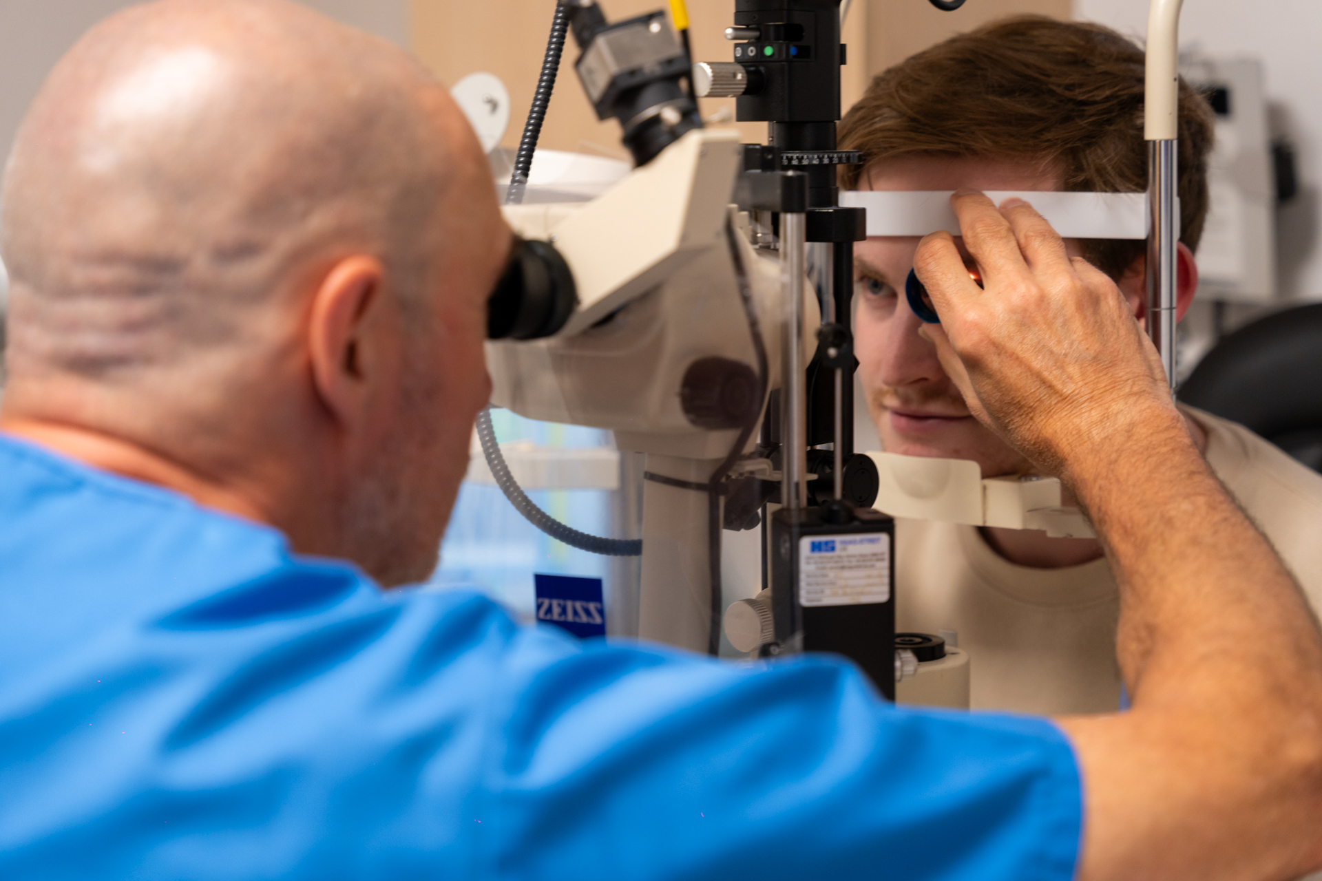 Eye doctor performs eye exam using professional optical examination equipment