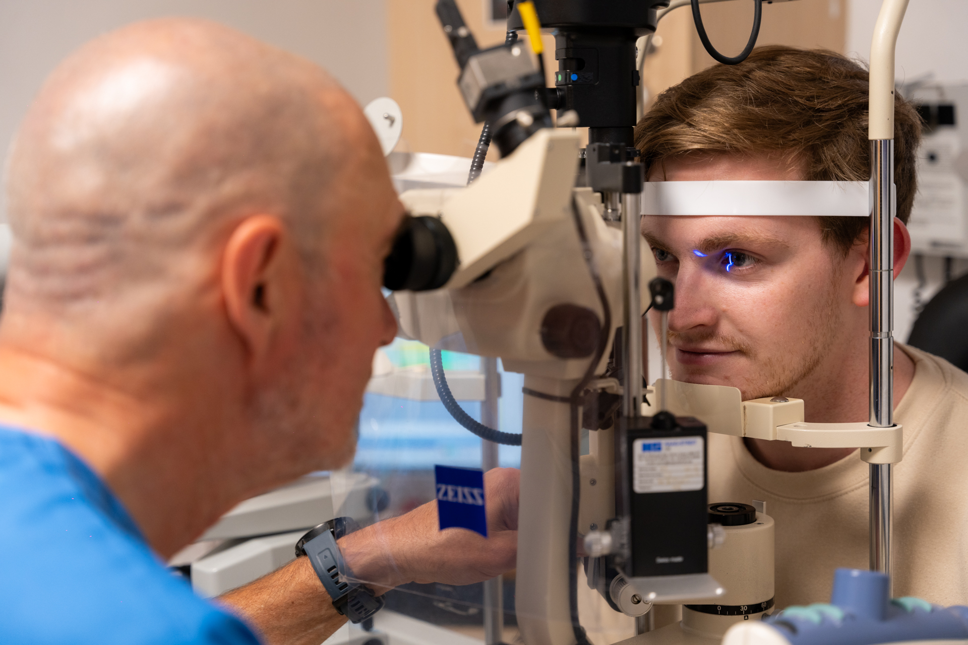 Eye doctor performs eye exam using slit lamp microscope