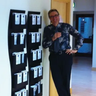 Person standing next to display board with multiple white papers