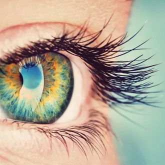 Macro close-up of vibrant blue and yellow human eye with long eyelashes