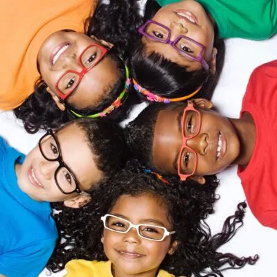 Diverse group of smiling children with glasses huddled together