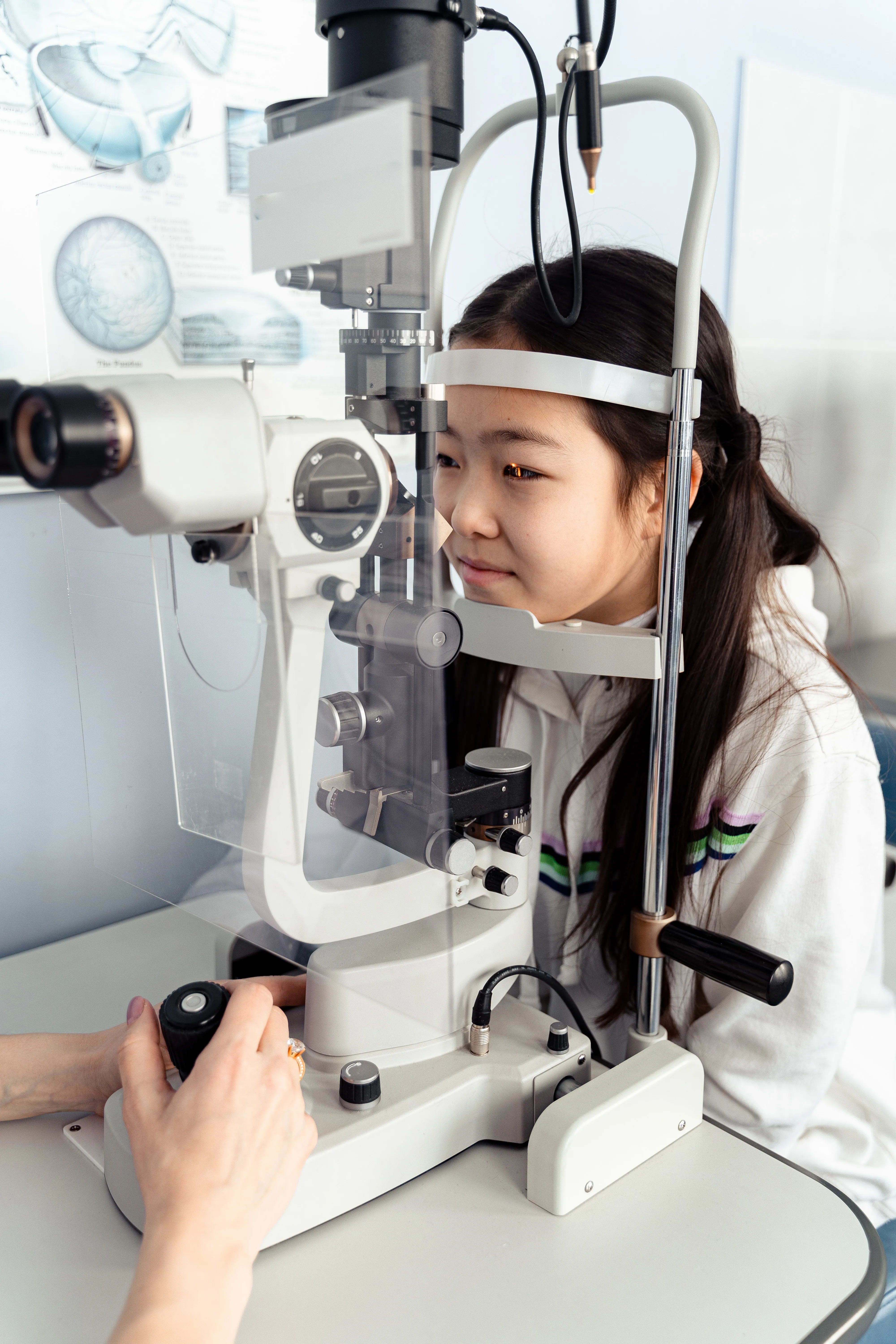 Child receiving eye exam with professional slit lamp ophthalmology equipment