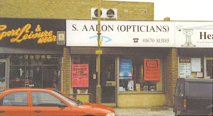 S. Aaron Opticians storefront with orange car parked outside