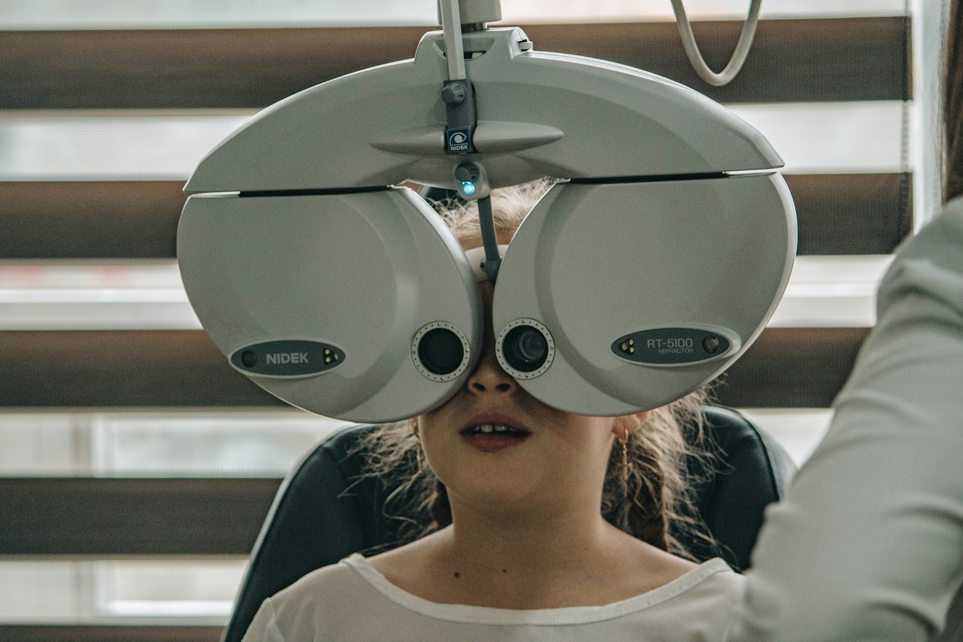 Child undergoing eye exam with professional optometry equipment