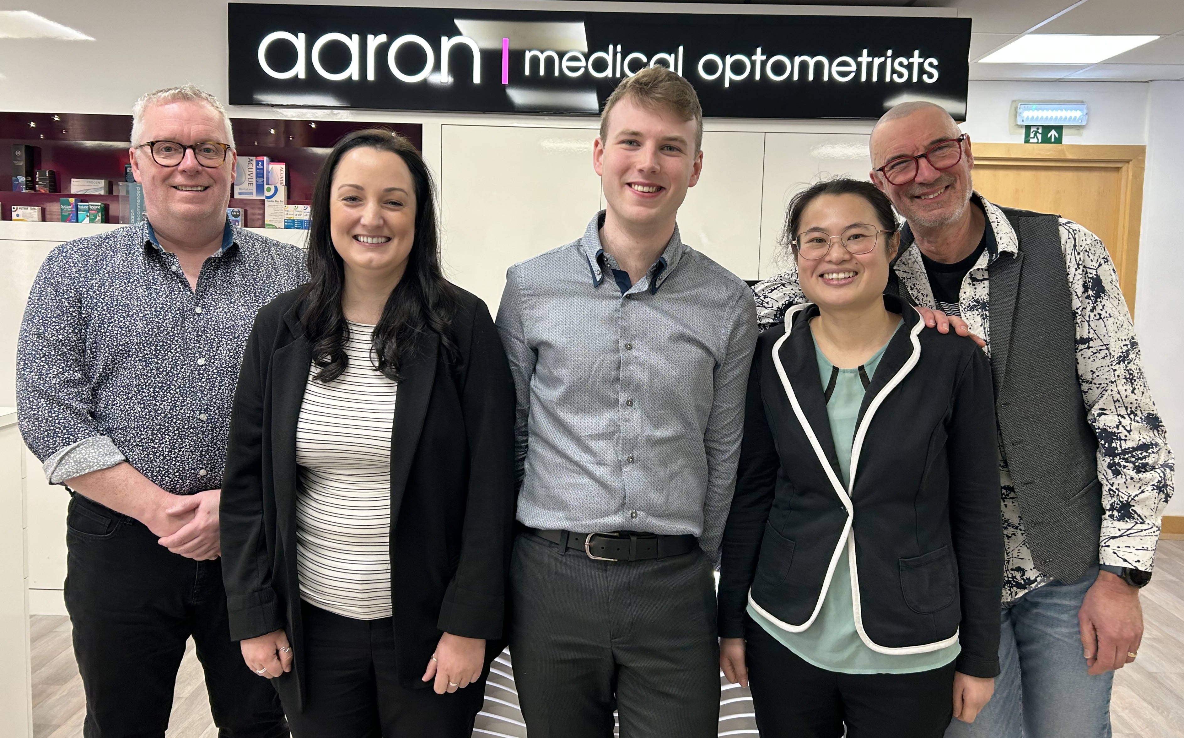 Five team members posing together at Aaron Medical Optometrists office