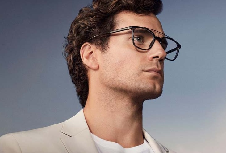 Profile of a stylish person wearing black-rimmed glasses and a white blazer