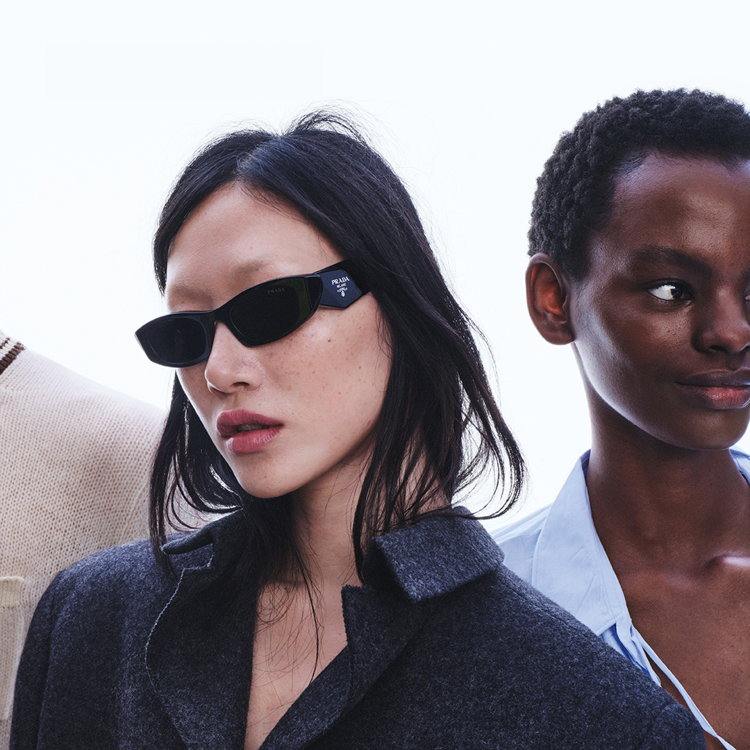 Two models wearing dark sunglasses and winter coats in minimalist portrait