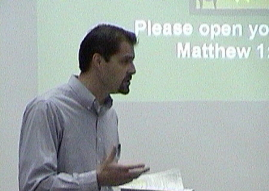 A grainy picture of Steve preaching at an early Harvest Church service, when the church was meeting at Lopez High School