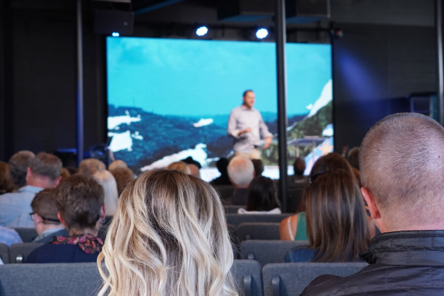 Photo of the back of people’s heads looking forward during a Sunday service in the new Worship Center at Harvest Church in the Village of Arroyo Grande